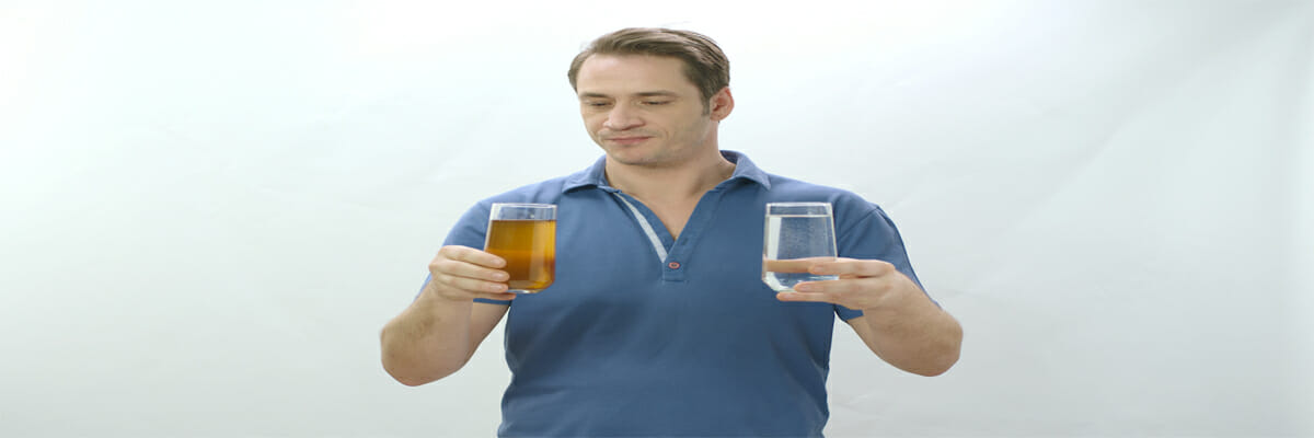 a man holding clean and brown tap water