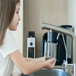A girl uses glass to conserve water.