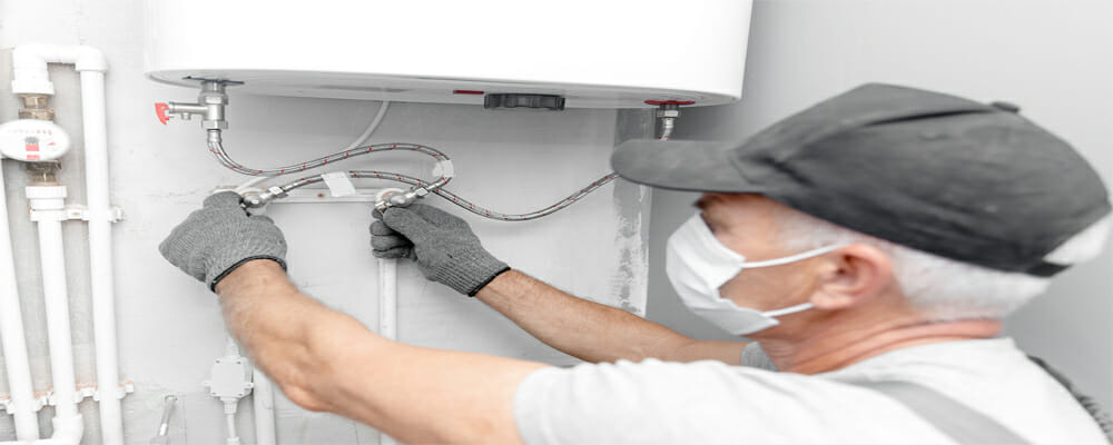 A man checks the water heater to see if it uses gas or electric