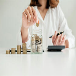 A woman is counting and calculating her coins