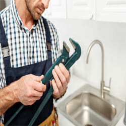 a plumber holds a tool for maintenance