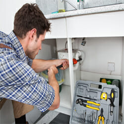 a professional plumber fixes the drain